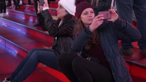 Due ragazze a Times Square di notte si siedono sui famosi gradini rossi — Video Stock