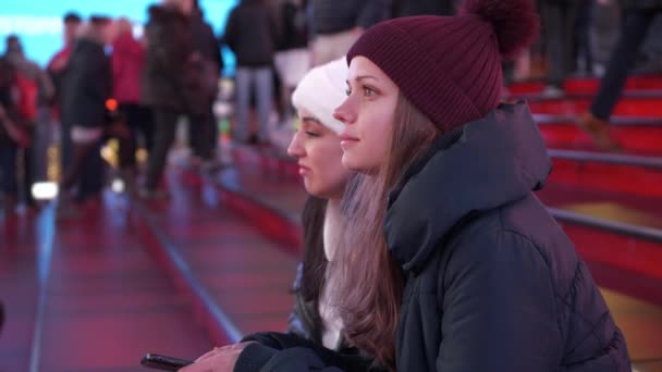 Dos chicas en Times Square por la noche se sientan en los famosos escalones rojos — Vídeos de Stock