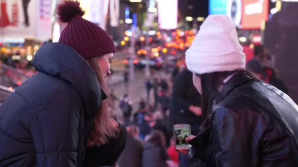 Dwie dziewczyny w Nowym Jorku podziwiać niesamowity widok na Times Square nocą — Wideo stockowe