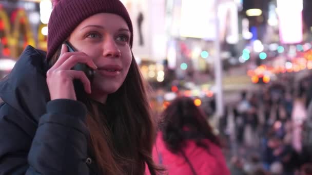 Jonge vrouw duurt een telefoontje op Times Square per nacht — Stockvideo