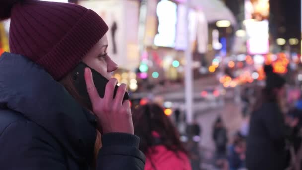 Fiatal nő vesz egy telefonhívást a Times Square éjjel — Stock videók