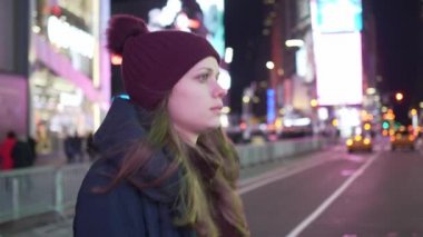 Güzel kız Times Square New York şehri ile gece yürür.