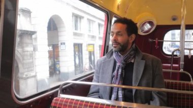 Adam eski bir Londra otobüs şehrin içinden seyahat ederken oturur