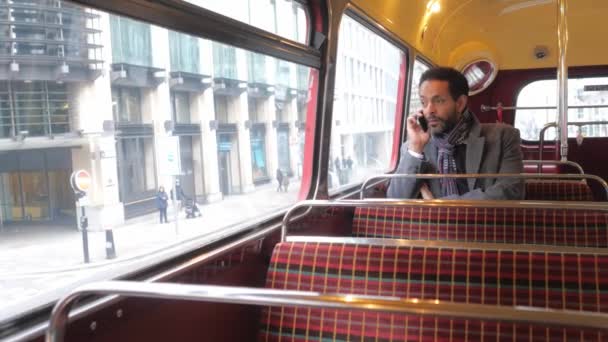 Homem senta-se em um velho ônibus londrino enquanto viaja pela cidade — Vídeo de Stock