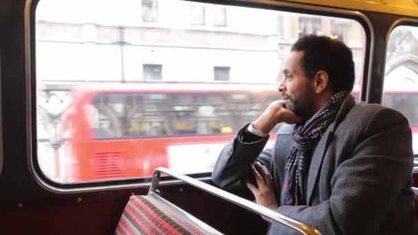 Man sitter i en gammal London buss medan du reser genom staden — Stockvideo