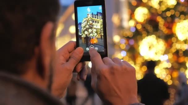 Man neemt een foto van een kerstboom — Stockvideo