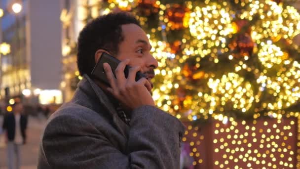 Мужчина отвечает на телефонный звонок в украшенном рождеством Лондоне — стоковое видео