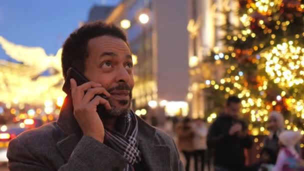 Man neemt een telefoontje in de kerst versierd city of London — Stockvideo