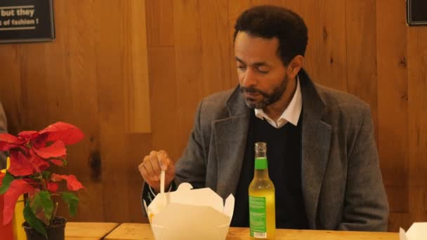 Mann im Restaurant isst Wurst mit Pommes — Stockvideo