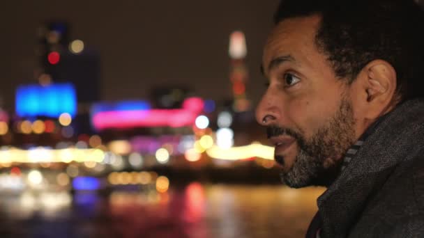 Geschäftsmann in London mit Blick auf die bunten Lichter der Stadt bei Nacht — Stockvideo