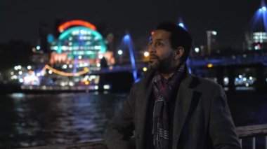 Afrika siyah adam gece Londra'da Thames Nehri boyunca yürür