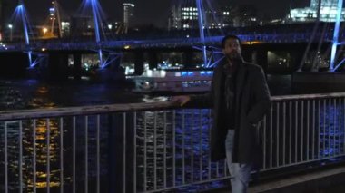 Afrika siyah adam gece Londra'da Thames Nehri boyunca yürür