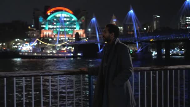 Afrikansk sort mand går langs Themsen i London om natten – Stock-video