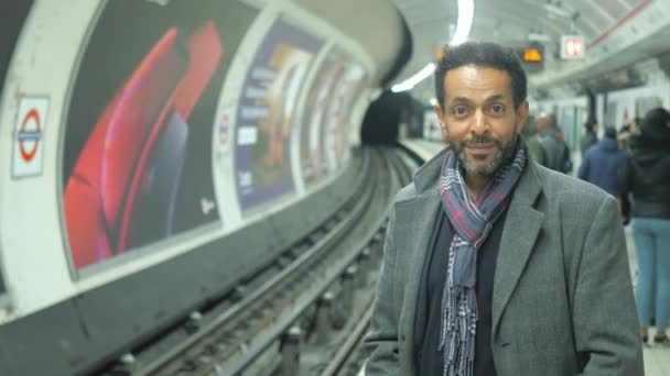 Homem negro em uma estação de metrô de Londres sorri para a câmera — Vídeo de Stock