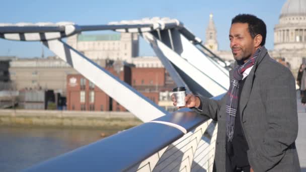 Afryki czarny człowiek cieszy widok nad rzeka Thames Londyn z Millennium Bridge — Wideo stockowe
