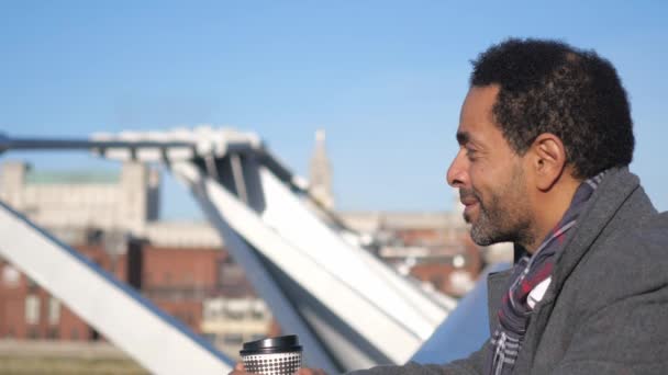 Африканский чернокожий наслаждается видом на Темзу с моста Миллениум — стоковое видео