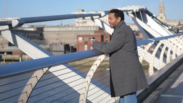 Hombre negro africano disfruta de la vista sobre el río Támesis Londres desde Millennium Bridge — Vídeo de stock