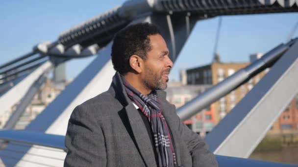 Africano homem negro goza da vista sobre o Rio Tâmisa Londres a partir de Millennium Bridge — Vídeo de Stock