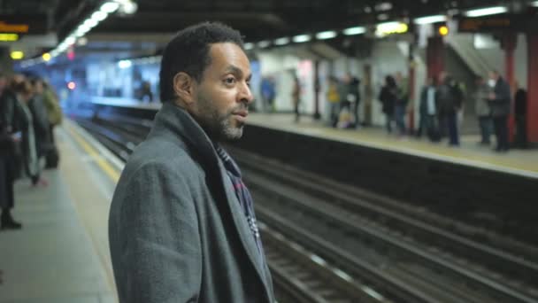 Hombre negro espera el tren en la estación de metro de Londres — Vídeos de Stock