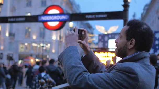 Siyah adam, Piccadilly Circus gezi - Londra - İngiltere'de iken - 15 Aralık 2018 fotoğraf çeker — Stok video