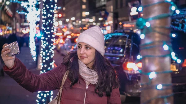 Young woman takes selfies while shopping for Christmas — Stock Photo, Image