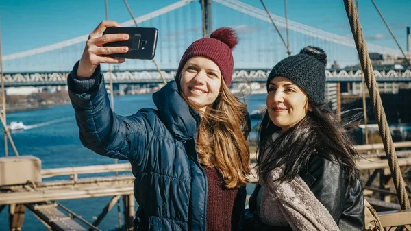 Dos amigos en Nueva York caminan por el famoso puente de Brooklyn — Foto de Stock