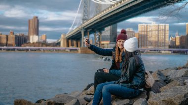 İki kız Manhattan Bridge adlı oturup tadını onların turistik gezi New York'a - seyahat fotoğrafçılığı