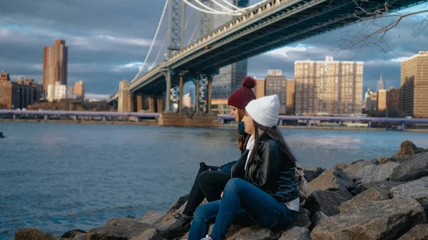 Two girls sit at Manhattan Bridge and enjoy their sightseeing trip to New York — Stock Photo, Image
