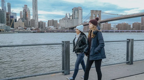 Dois amigos caminham ao longo do incrível horizonte de Manhattan à noite — Fotografia de Stock