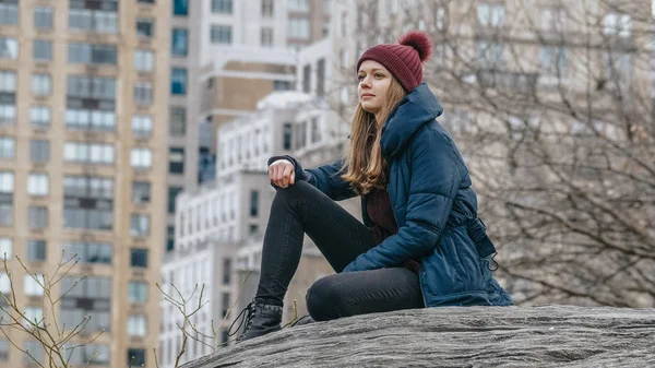 Une jeune femme se détend sur un rocher à Central Park New York — Photo