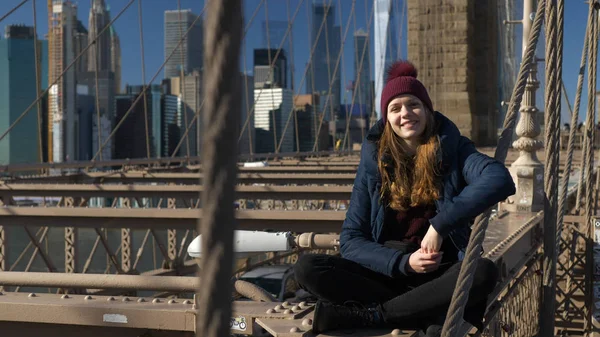 Belle fille sur Brooklyn Bridge bénéficie d'une journée ensoleillée tout en se relaxant — Photo