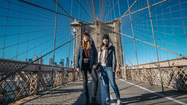 Due ragazze camminano sul famoso ponte di Brooklyn a New York — Foto Stock