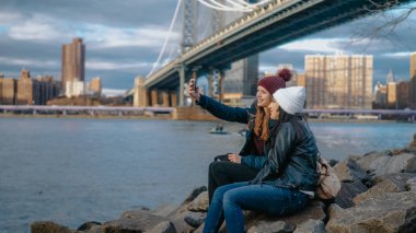 İki kız Manhattan Bridge oturup kendi turistik gezi New York'a tadını çıkarın