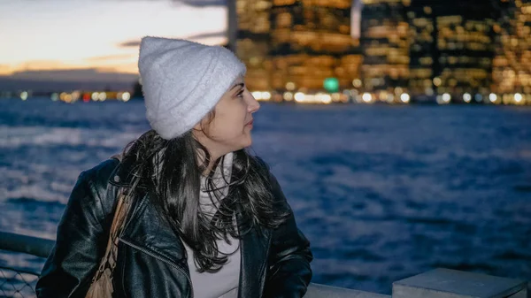 Mujer joven disfruta de la fantástica vista sobre el horizonte de Manhattan por la noche — Foto de Stock