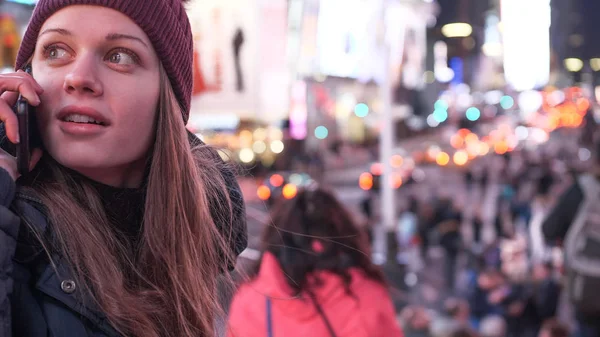Young woman takes a phone call on Times Square by night — Stock Photo, Image