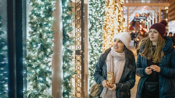 Two girls in New York look at Christmas decorated shop windows — Stock Photo, Image