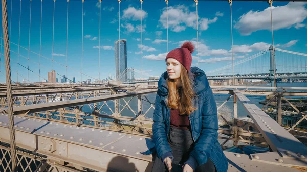 Joven hermosa mujer se relaja en el puente de Brooklyn mientras disfruta de la increíble vista — Foto de Stock