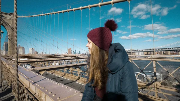 Mooie jongedame ontspant op Brooklyn Bridge terwijl u geniet van de prachtig uitzicht — Stockfoto