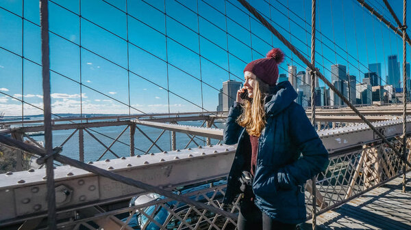 Two friends in New York walk over the famous Brooklyn Bridge - travel photography