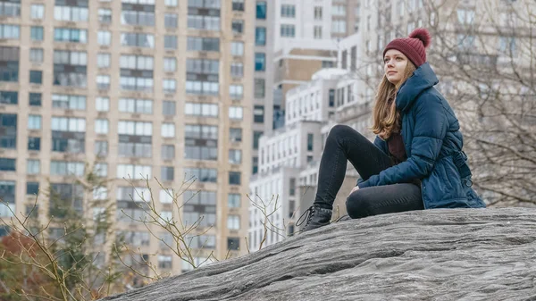 Une jeune femme se détend sur un rocher à Central Park New York — Photo