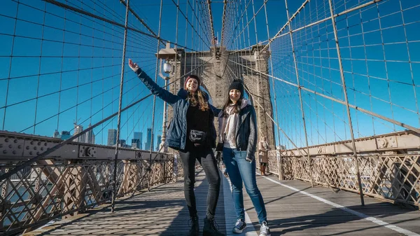 Due ragazze camminano sul famoso ponte di Brooklyn a New York — Foto Stock