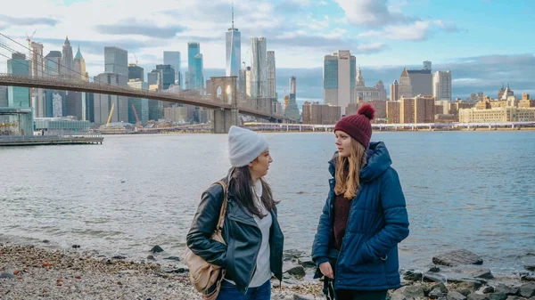 New York'ta iki genç kadın nefes kesen Manhattan siluetinin tadını çıkarın. — Stok fotoğraf