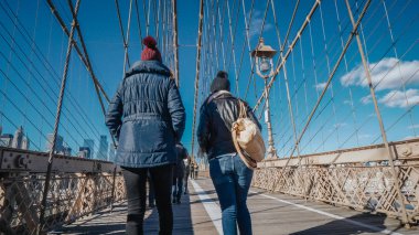 İki kız New York'ta ünlü Brooklyn Köprüsü üzerinde yürümek
