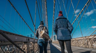İki kız New York'ta ünlü Brooklyn Köprüsü üzerinde yürümek