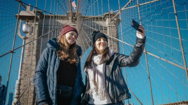 İki kız New York'ta ünlü Brooklyn Köprüsü üzerinde yürümek