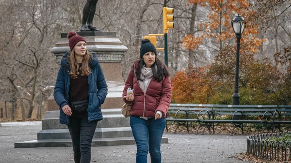 Две молодые женщины во время поездки в Нью-Йорк совершают расслабляющую прогулку в Центральном парке — стоковое фото