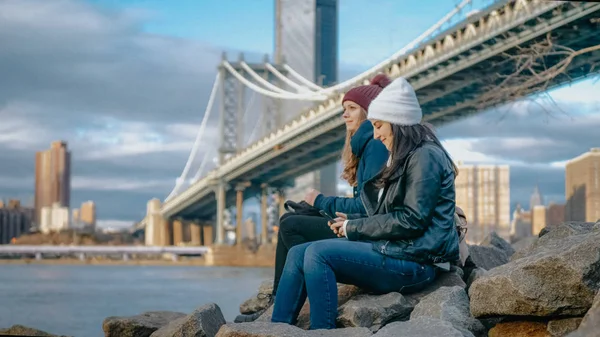 Deux filles s'assoient au Manhattan Bridge et profitent de leur voyage touristique à New York — Photo