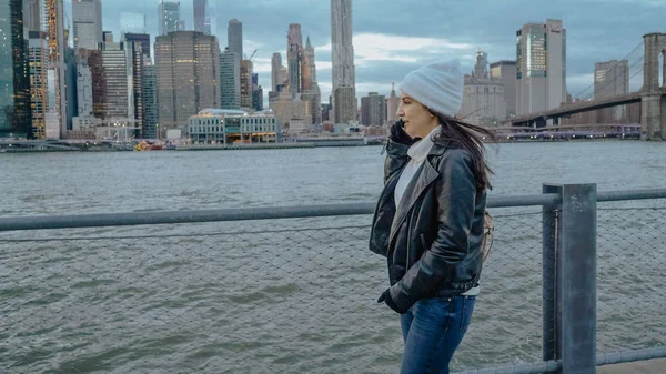 Jeune femme marche le long de la magnifique skyline de Manhattan dans la soirée — Photo