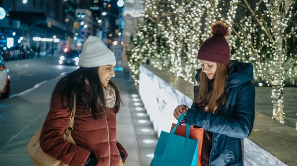 Two girls in New York at Christmas time enjoy shopping presents — Stock Photo, Image