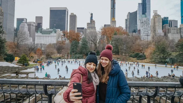 Two friends look over the ice rink at Central Park on a winters day — Stock Photo, Image